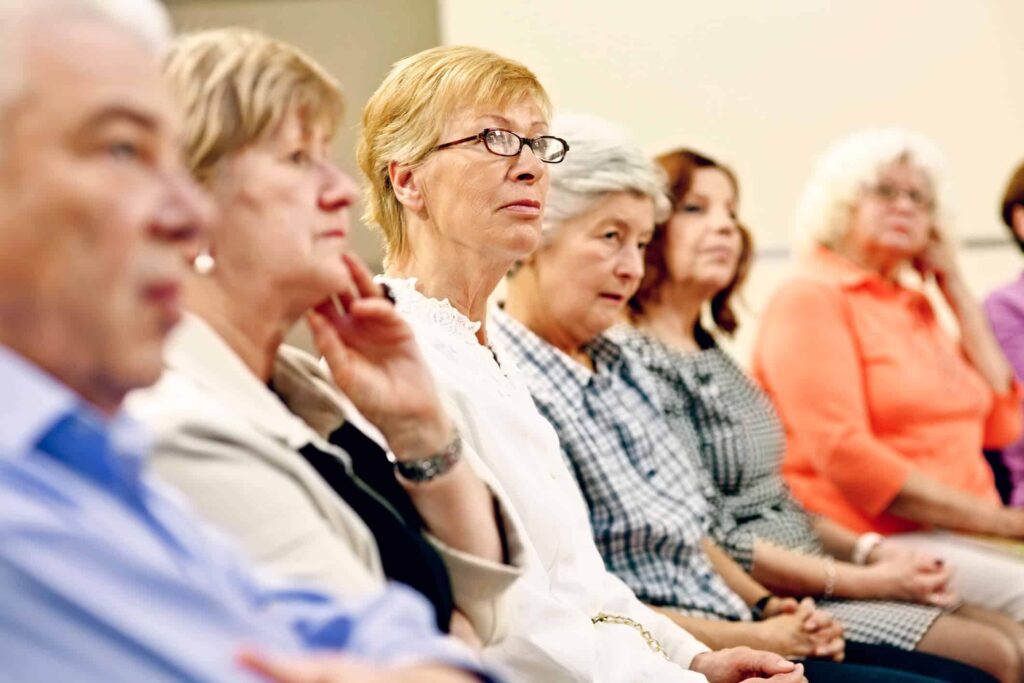 People sitting at desks listening to teacher