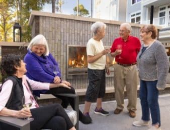 people taking on patio with fireplace behind them